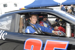 Passenger and driver in stock car